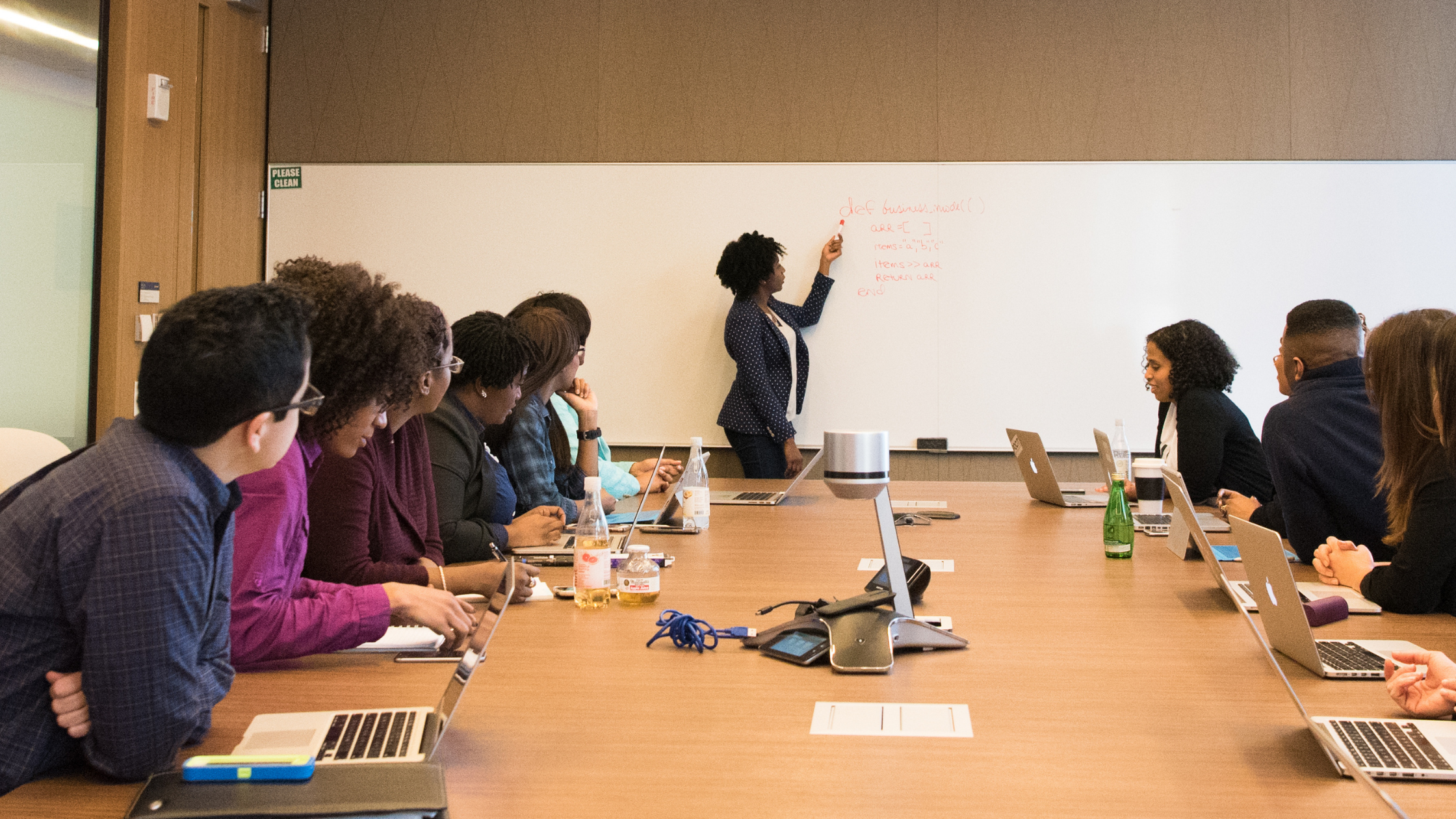 A Black woman leads her business team in a meeting. The Racial Wealth Gap, Black Owned Businesses, and USI's Steps to Close It